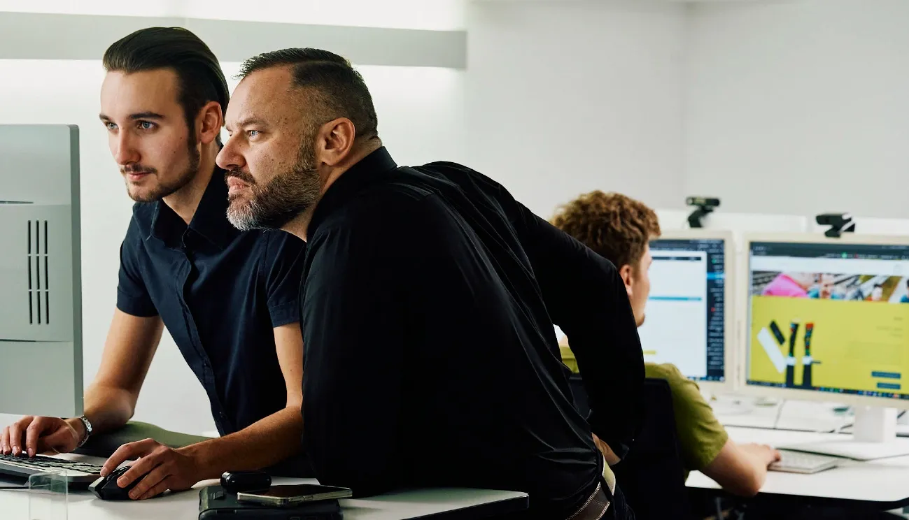 Wir vertrauen auf Shopware arven.io Mitarbeiter an einem Schreibtisch und besprechen ein Shop-Projekt